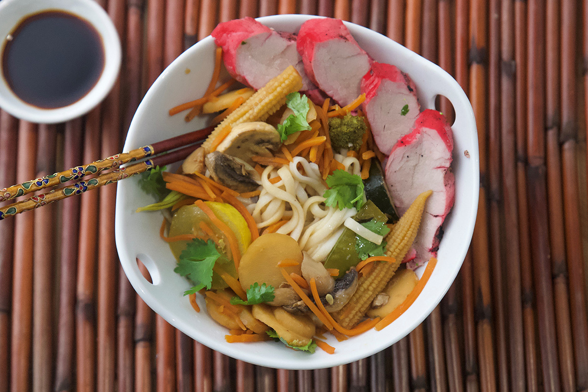 Char siu stir fry made with Prairie Fresh® pork tenderloin, soba noodles, baby corn, mushrooms and vegetables in bowl.